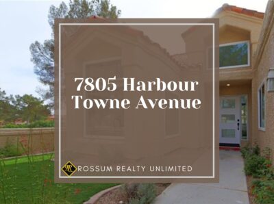 Featured image of 7805 Harbour Towne Avenue, showcasing a tan stucco townhome with a well-maintained, elegant exterior. The property exudes warmth and sophistication, set against a backdrop of lush landscaping and clear blue skies, highlighting its inviting ambiance and architectural charm.