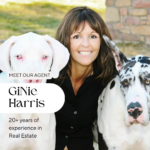 Alt text: "Image of GiNie Harris, team leader of LV neighborhood real estate pros, smiling alongside two large dogs, one white and one with black and white spots. Text overlay includes 'MEET OUR AGENT GiNie Harris' with '20+ years of experience in Real Estate' below her name."